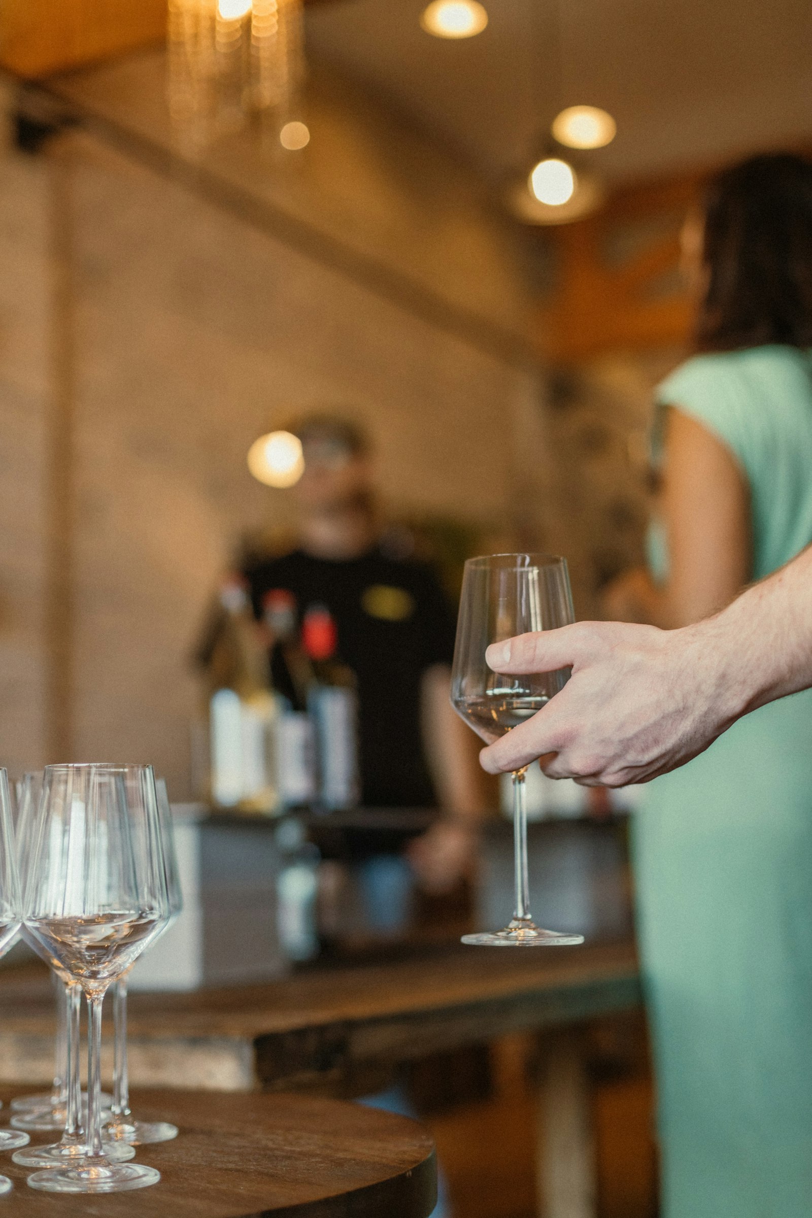 Pessoa segurando uma taça durante uma degustação de vinho para ilustrar o passo a passo de degustação