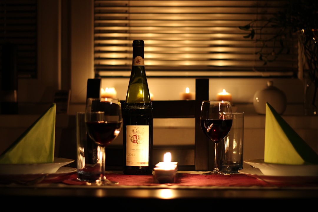 Garrafa e taça de vinho em mesa para guia de melhores vinhos até R$100