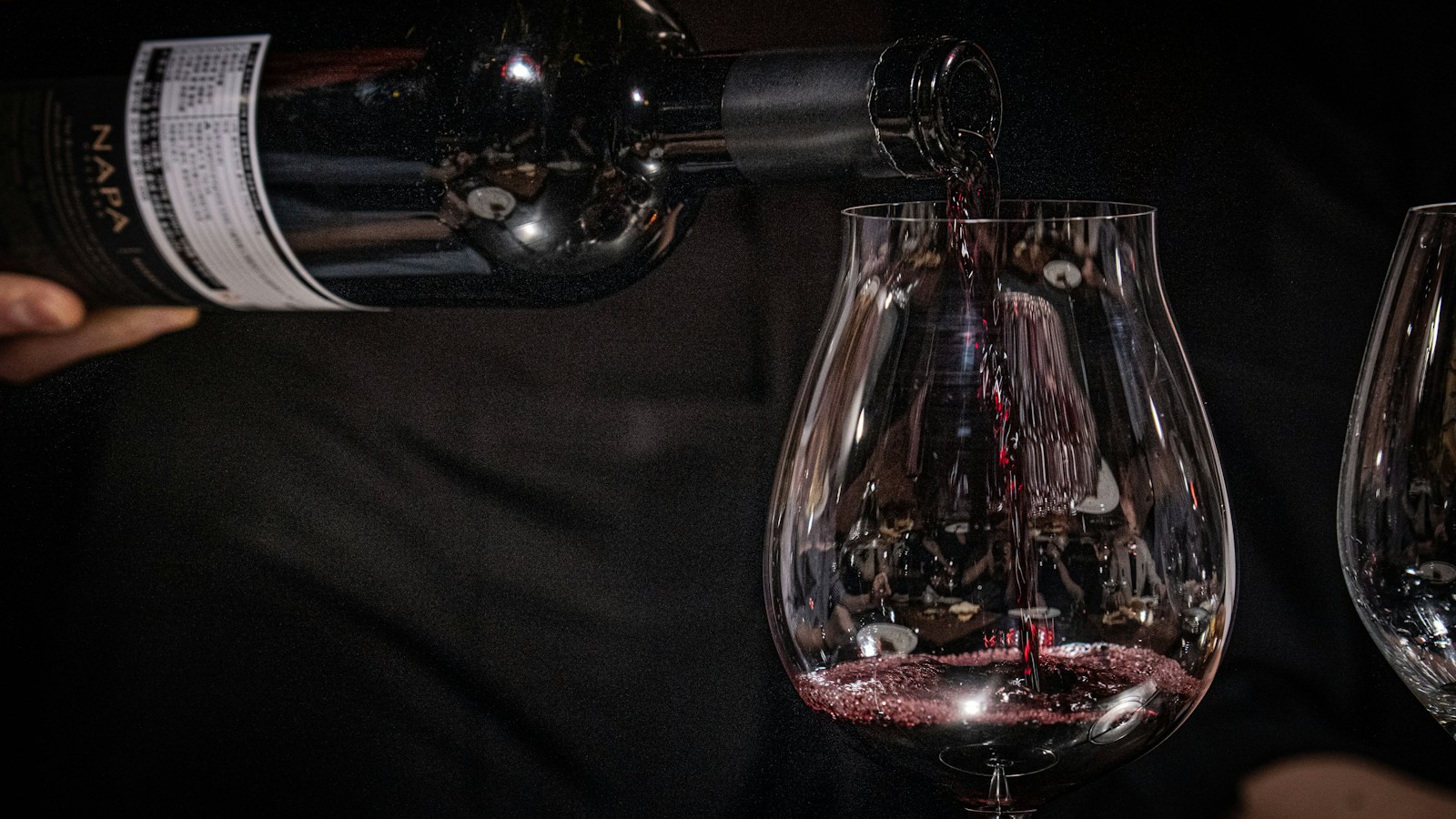 Vinho tinto sendo servido em taça para ilustrar a comparação entre Cabernet Sauvignon e Merlot