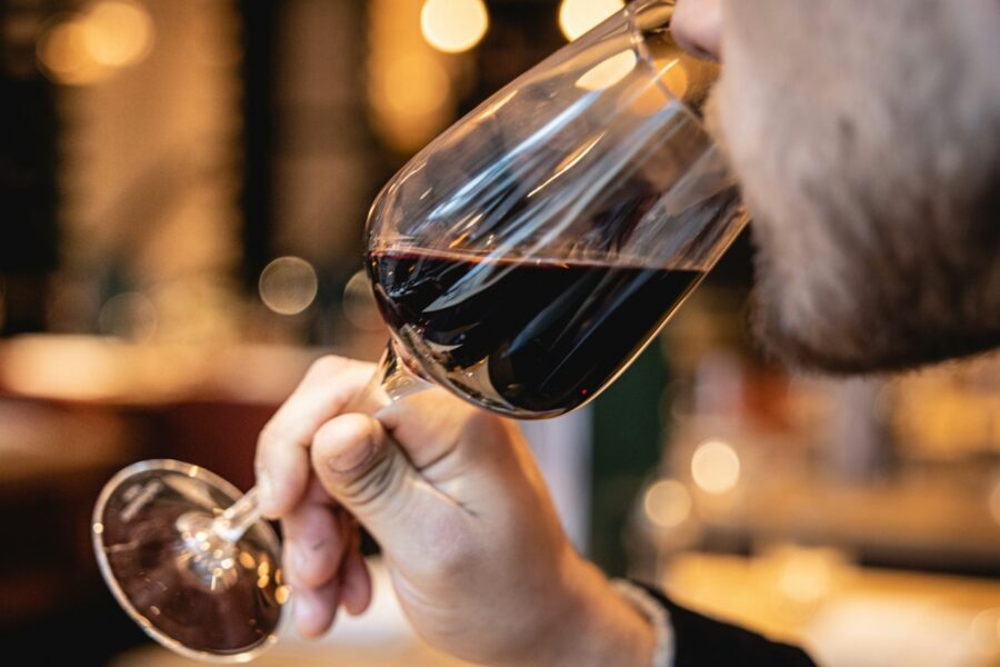 Pessoa degustando vinho tinto para ilustrar o processo de aeração e decantação do vinho