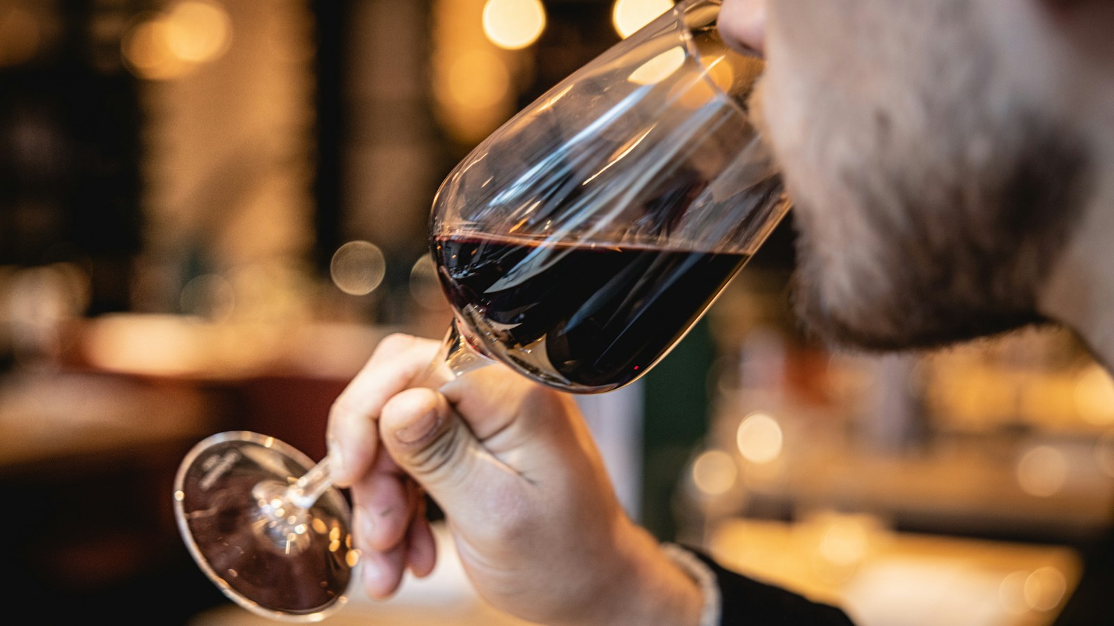 Pessoa degustando vinho tinto para ilustrar o processo de aeração e decantação do vinho