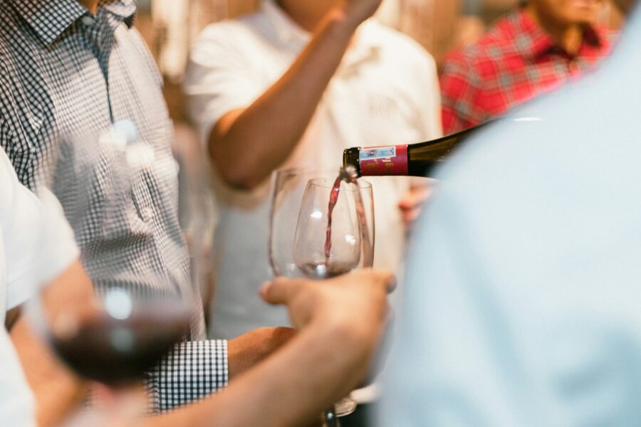 Pessoas segurando taças de vinho em encontro ligado ao universo do vinho