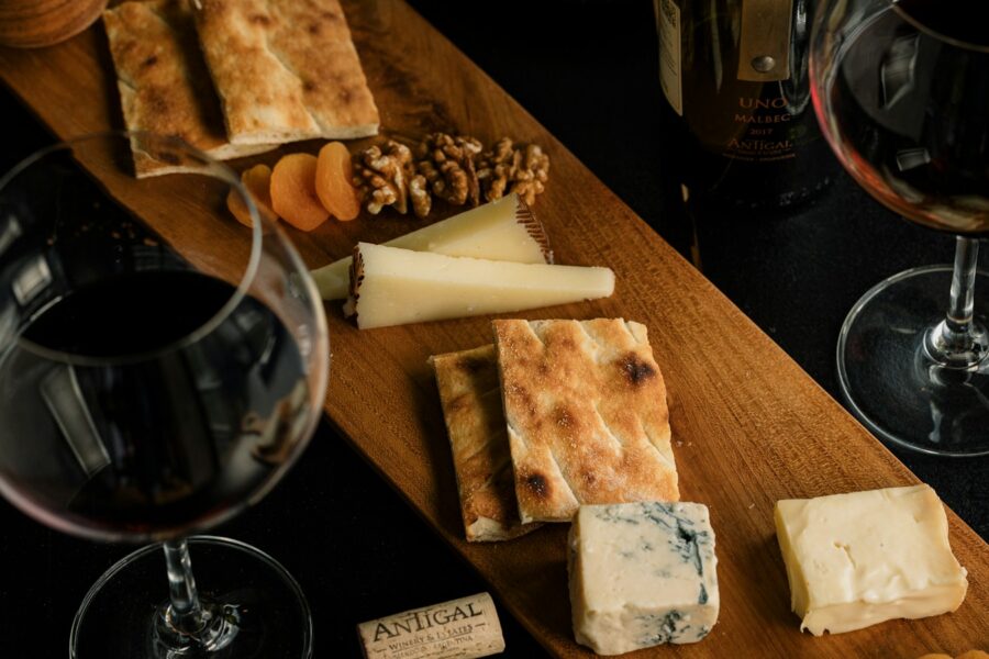 Mesa com vinho e queijos para ilustrar harmonização entre vinho e queijo