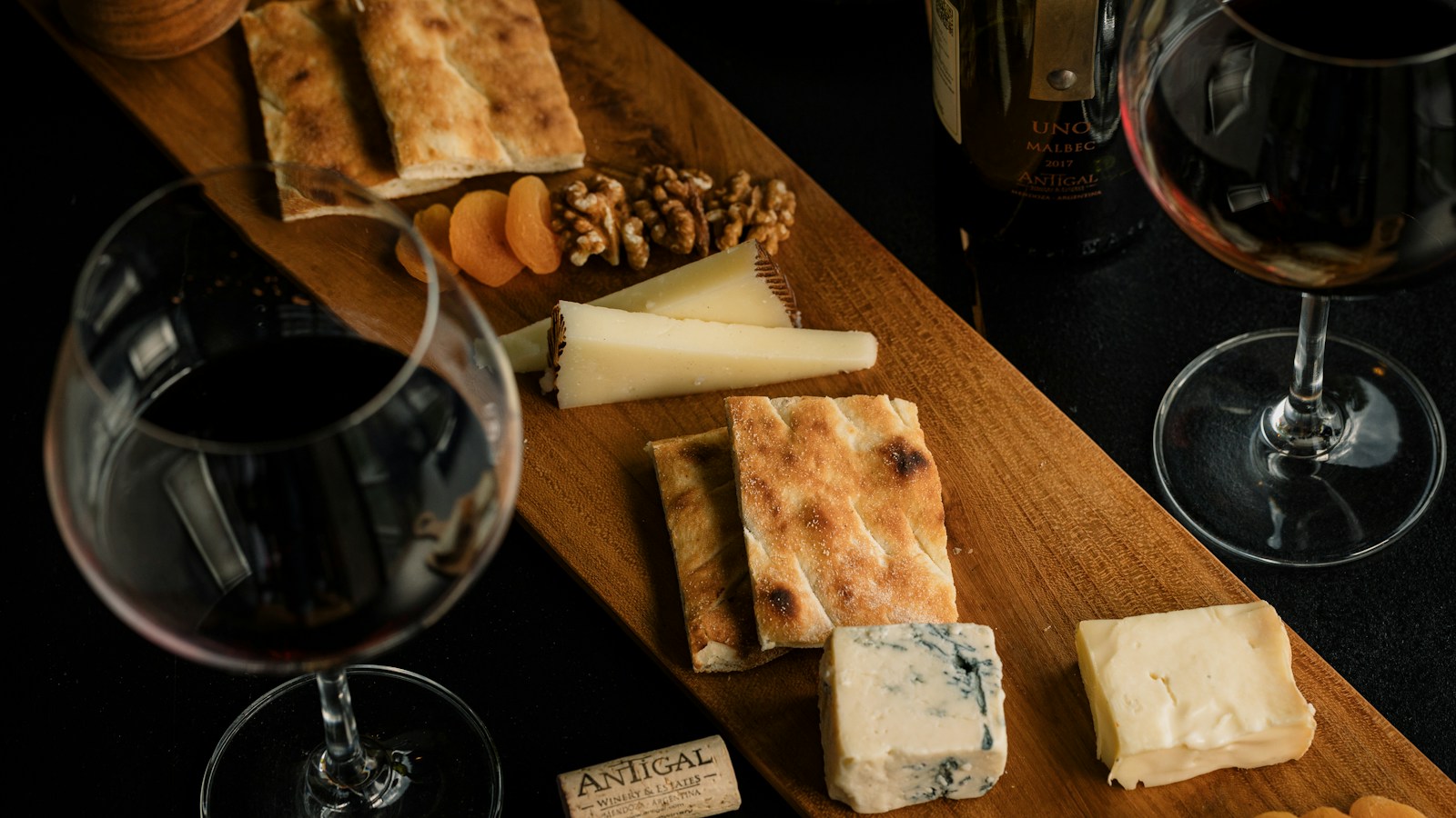 Mesa com vinho e queijos para ilustrar harmonização entre vinho e queijo