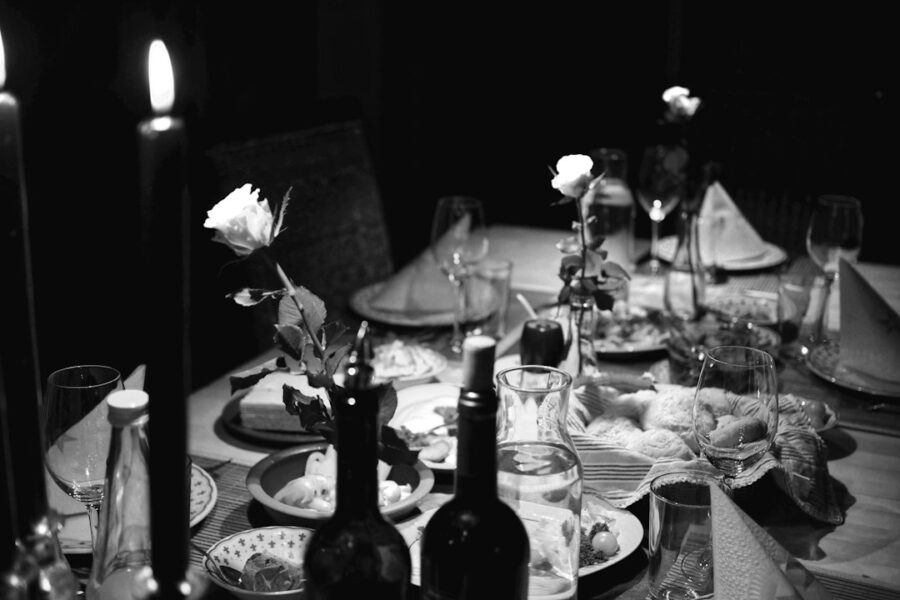 Taça de vinho ao lado de pratos em uma mesa de jantar
