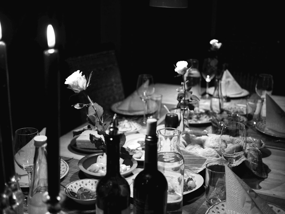 Taça de vinho ao lado de pratos em uma mesa de jantar